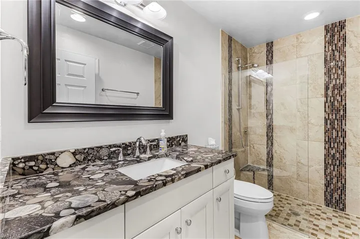 Full bath featuring vanity, a stall shower, and recessed lighting located between the 2 Guest bedrooms