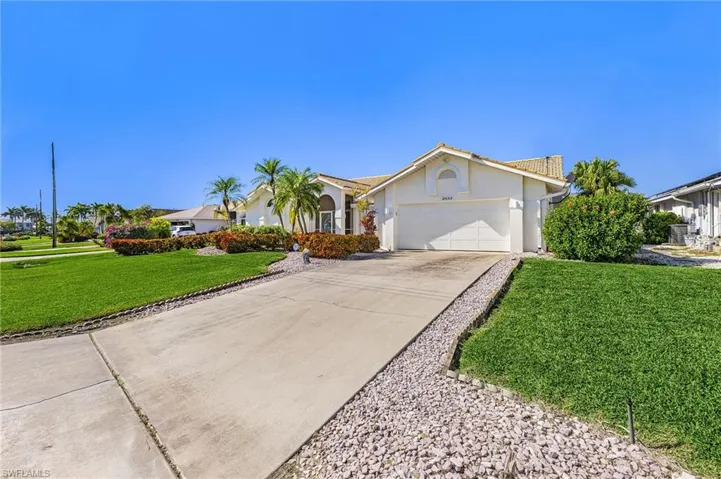 Ranch-style house featuring stucco siding, a front lawn, concrete driveway, and an attached oversized two car garage