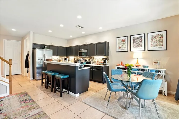ChatGPT said:Open-concept living area seamlessly connects the kitchen, dining, and family room, creating the perfect flow for entertaining. Modern dark cabinetry, stainless steel appliances, and a stylish backsplash complement the bright, inviting space. Tile floors, recessed lighting, and a neutral palette enhance the airy feel, while sliding doors lead to the screened pool and patio. Ideal for Florida living, this versatile layout offers comfort, functionality, and easy access to Gulf Coast attractions.
