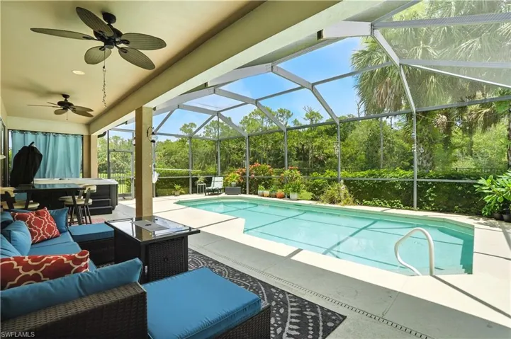 Stunning screened-in pool area with lush preserve views, offering ultimate privacy and a true Florida lifestyle. Covered patio with ceiling fans creates a perfect space for outdoor dining or relaxing in the shade. The sparkling pool is surrounded by tropical landscaping and ample deck space for lounging or entertaining. Ideal for year-round enjoyment, this backyard retreat blends comfort and nature—just minutes from Gulf beaches, shopping, and dining.