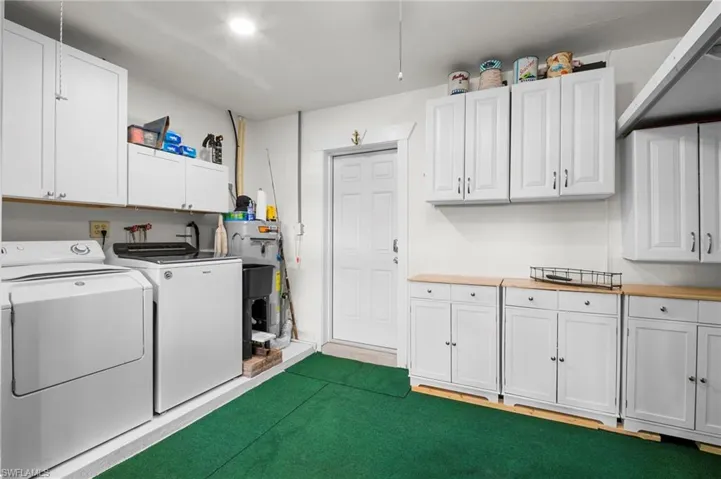 Laundry area featuring cabinet space, washer and clothes dryer, and gas water heater