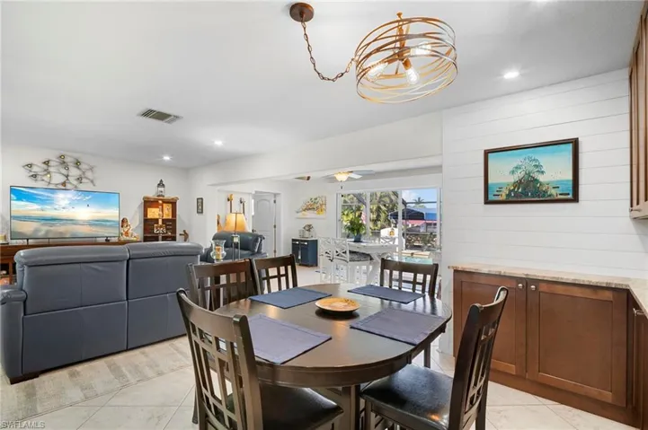 Dining area with recessed lighting, light tile patterned floors, and wood walls