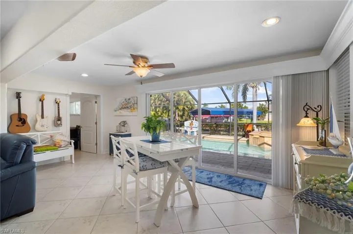 Dining area with a ceiling fan, a sunroom, light tile patterned floors, and recessed lighting