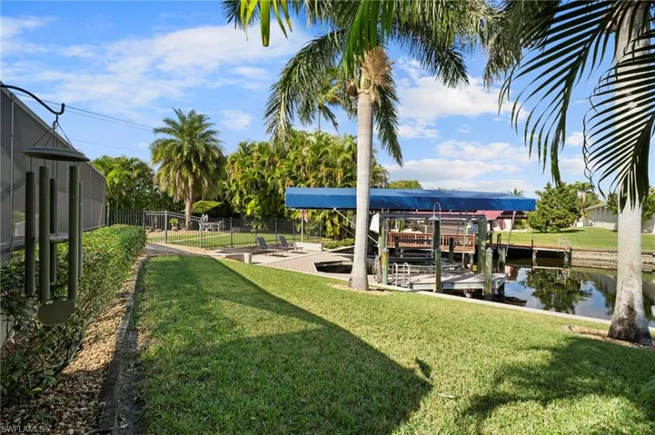 View of yard featuring boat lift, a boat dock, and a water view