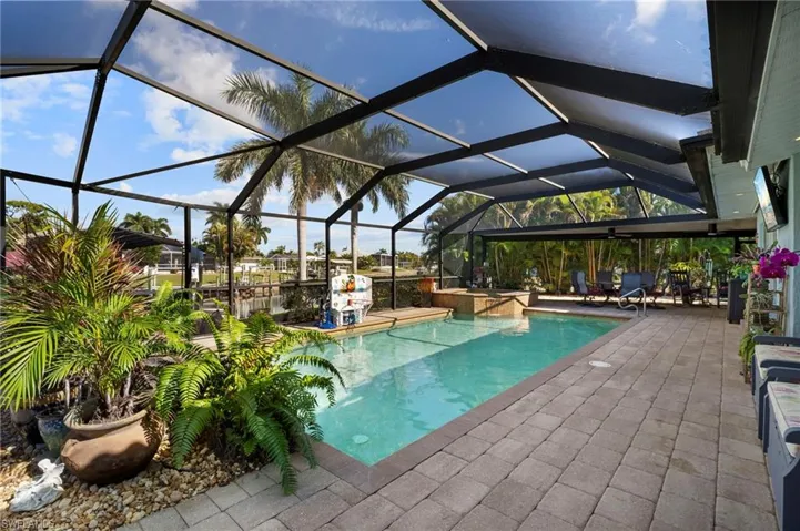 Swimming pool with a patio, a lanai, and a sunroom
