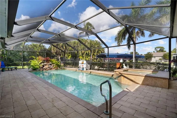 Swimming pool featuring a sunroom, glass enclosure, and a patio area