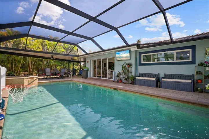 Outdoor pool featuring a sunroom, a lanai, and a patio area