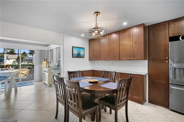 Dining area with suspended lighting and light tile patterned floors