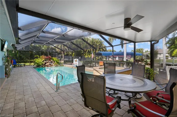 Outdoor pool with a patio area, a lanai, a sunroom, and outdoor dining space