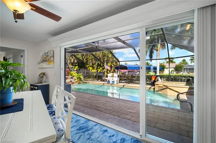 Outdoor pool featuring a sunroom and a ceiling fan