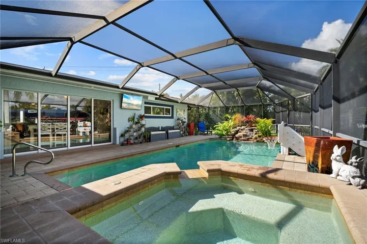 Integrated pool / hot tub featuring a sunroom, a patio area, and glass enclosure