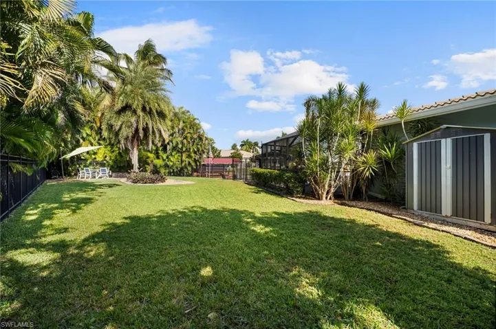 Fenced backyard featuring a storage shed