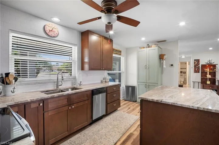 Kitchen featuring electric range, ceiling fan, light stone countertops, recessed lighting, and light wood-style flooring