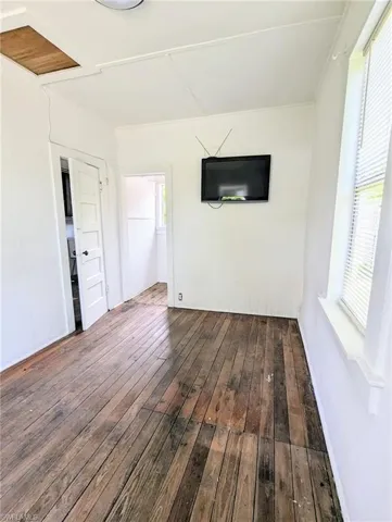 Unfurnished room featuring dark hardwood / wood-style floors