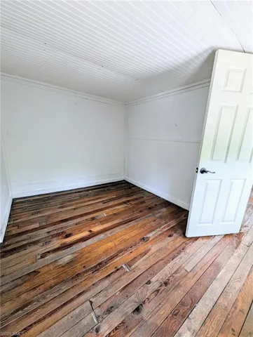 Spare room with wooden ceiling and dark hardwood / wood-style floors