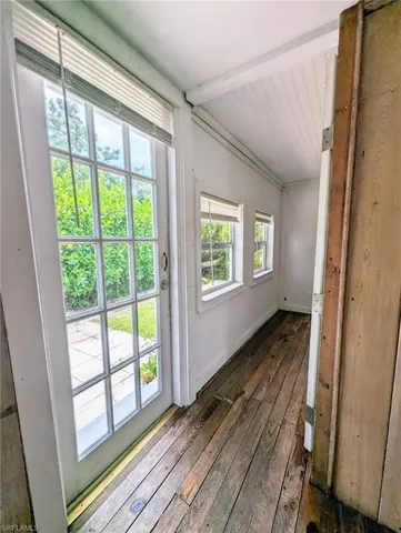 Doorway to outside with lofted ceiling and wood-type flooring