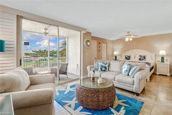 Tiled living area with a ceiling fan, and impact sliders