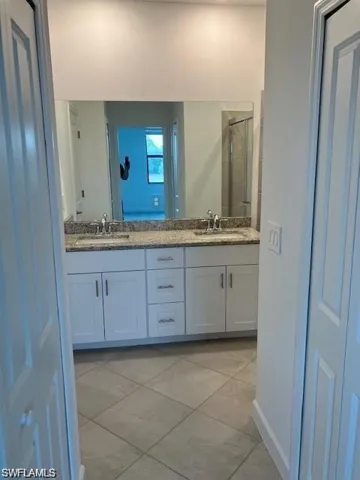 Bathroom with tile patterned floors and double sink vanity