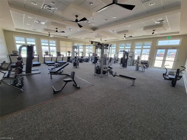 Workout area with ceiling fan, carpet, and a paneled ceiling