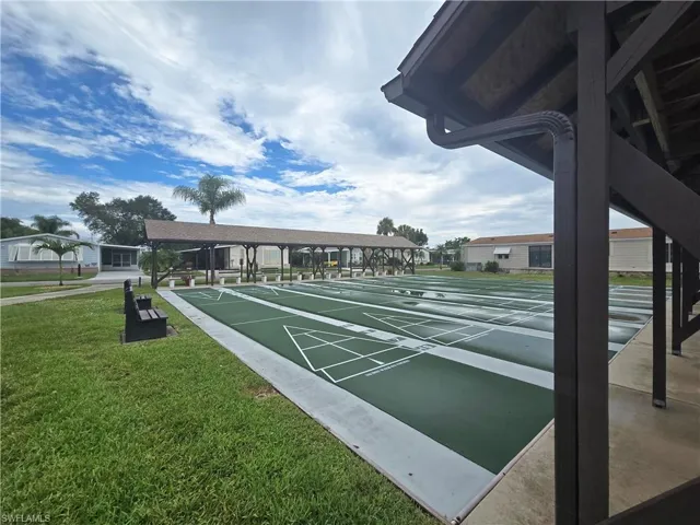 Surrounding community featuring shuffleboard and a yard