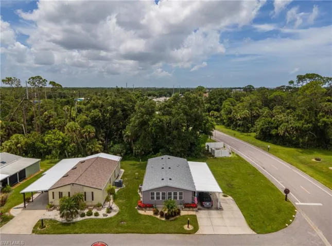 Aerial view of property and surrounding area featuring a forest