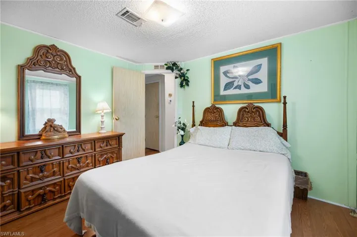 Bedroom with wood finished floors and a textured ceiling
