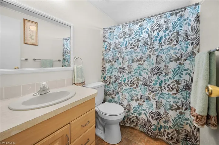 Bathroom featuring vanity, a shower with curtain, and tile patterned flooring