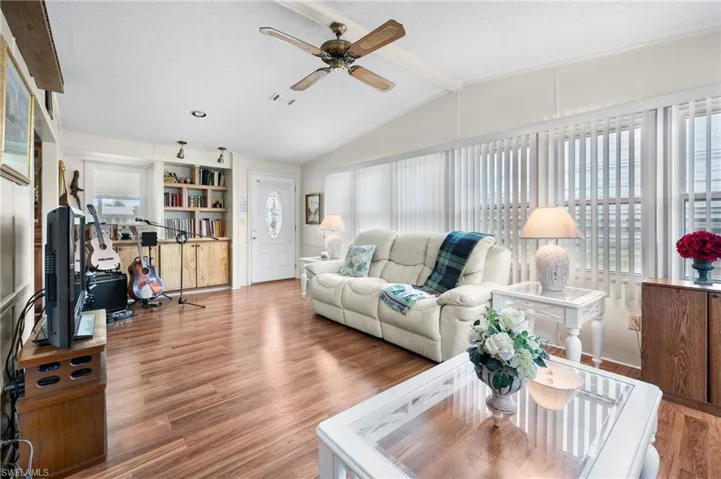 Living room with a textured ceiling, wood finished floors, and a ceiling fan