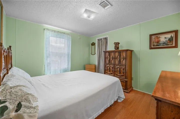 Bedroom with wood finished floors and a textured ceiling