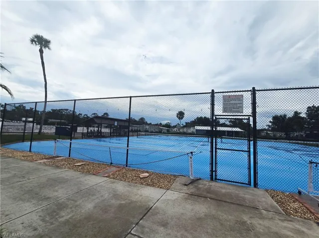 View of tennis court with a gate