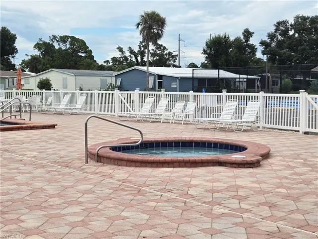 View of pool with a community hot tub and a patio