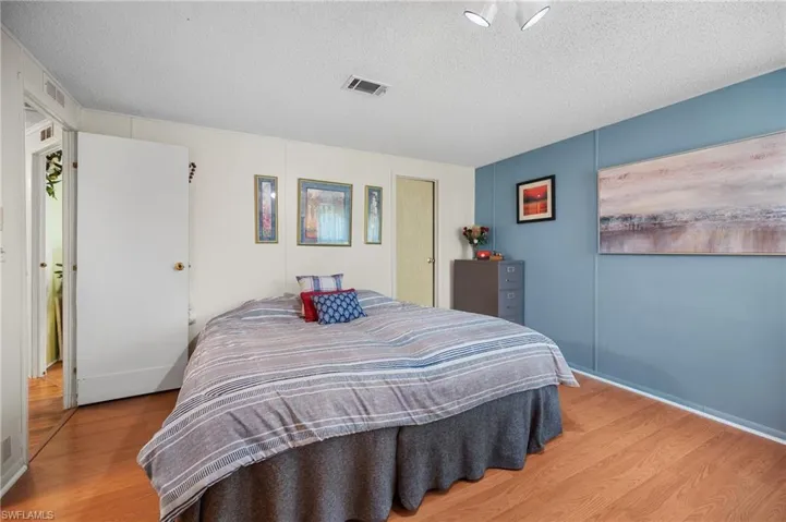 Bedroom with wood finished floors and a textured ceiling