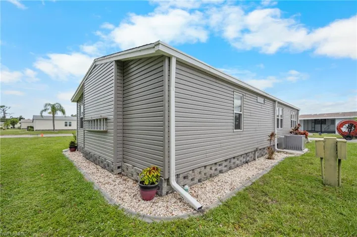 View of side of home featuring a yard and a cooling unit