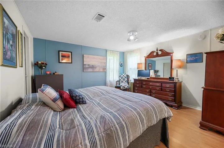 Bedroom featuring light wood finished floors and a textured ceiling