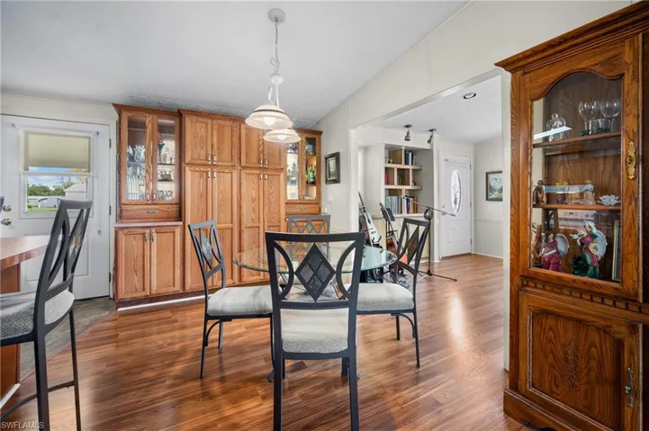 Dining space with dark wood-style floors, plenty of natural light, and a textured ceiling