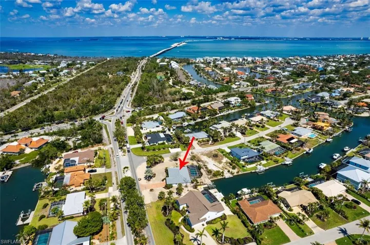 Aerial view of property and surrounding area featuring nearby suburban area and a nearby body of water