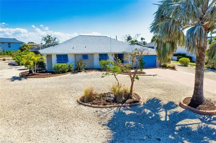 Ranch-style house with driveway, an attached garage, stucco siding, and a shingled roof
