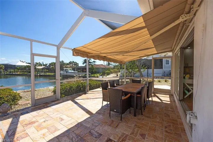 Sunroom / solarium with outdoor dining space, a water view, and a patio