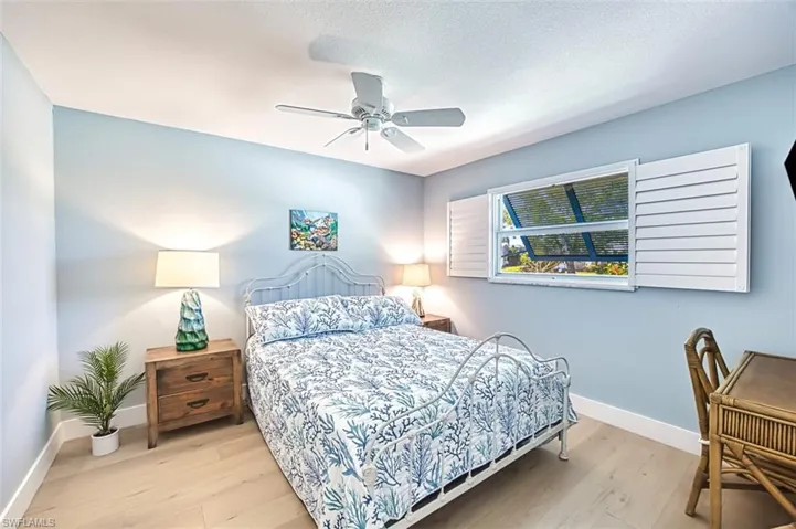 Bedroom with wood finished floors, a ceiling fan, and a textured ceiling