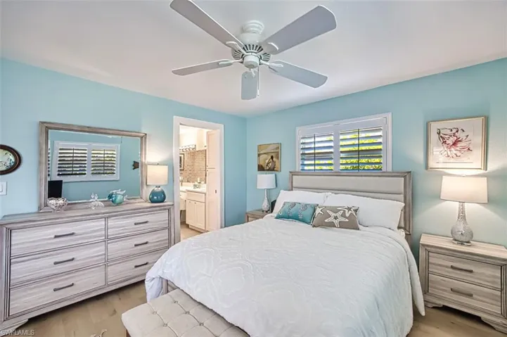 Bedroom featuring a ceiling fan, light wood-style floors, and connected bathroom
