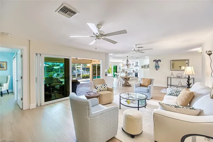 Living area featuring a ceiling fan, wood finished floors, and a chandelier
