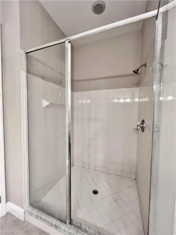 Full bath with a stall shower and tile patterned flooring