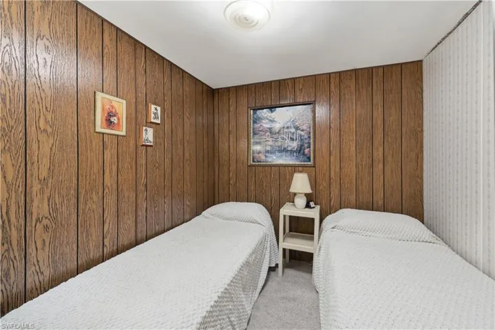 Bedroom featuring carpet flooring and wood walls