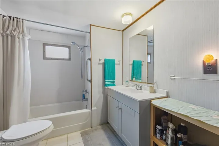 Full bathroom with shower / bath combo, vanity, and light tile patterned floors