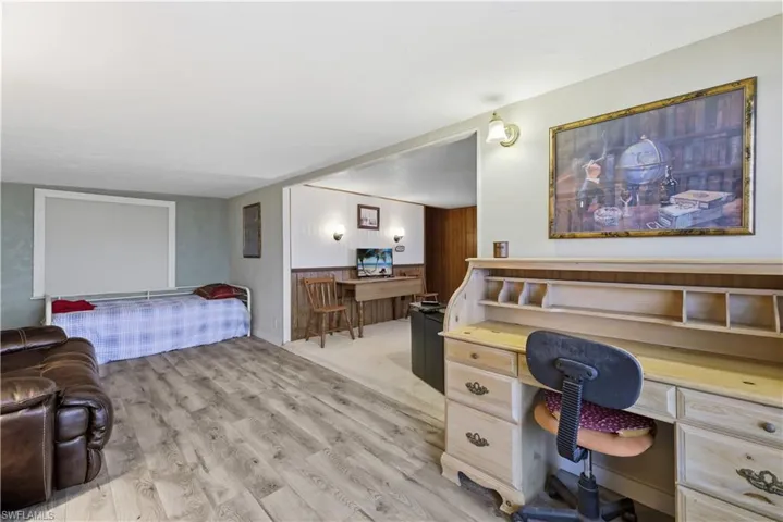 Bedroom featuring light wood-style flooring and built in desk