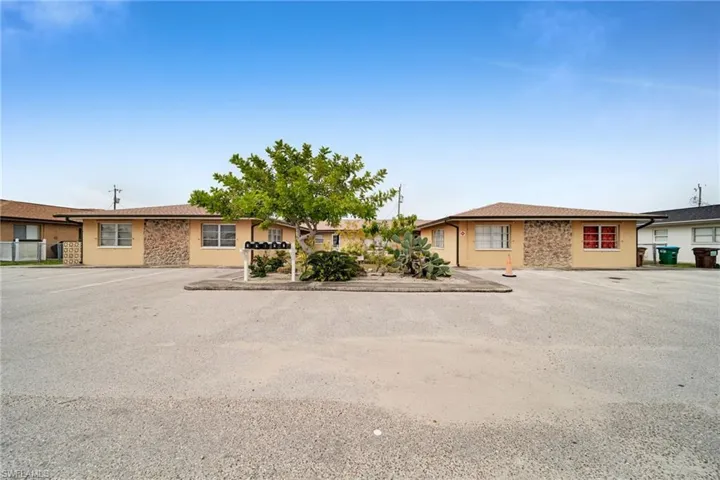 Ranch-style home with uncovered parking and stucco siding