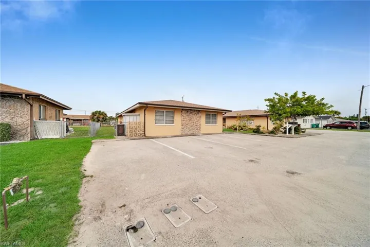 View of front of house featuring uncovered parking, a gate, and a residential view