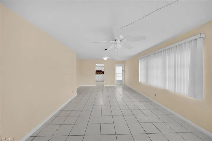 Unfurnished living room featuring light tile patterned flooring, ceiling fan, and a textured ceiling