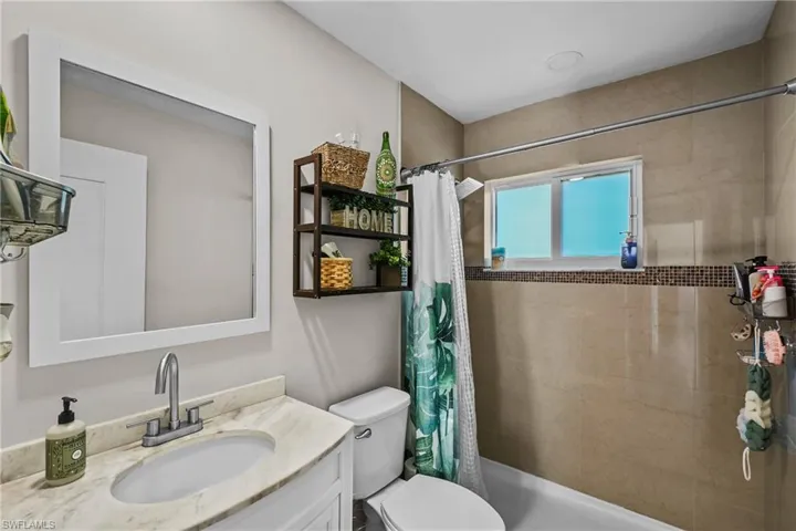 Bathroom with vanity and tiled shower