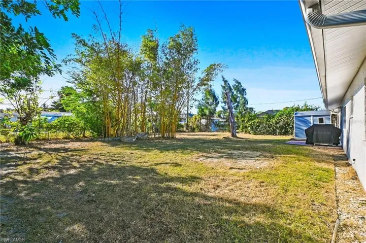 View of green lawn with a storage shed